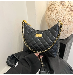 Détail du sac hobo en cuir matelassé noir avec chaîne dorée et fermoir rotatif