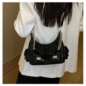 Detail of black quilted shoulder bag featuring gold chain strap and multiple cargo pockets
