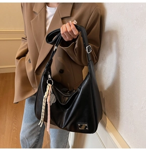 Detail of black large capacity shoulder bag with adjustable strap and textured PU leather