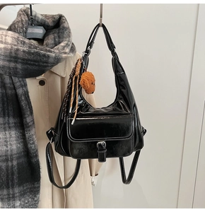Détail du sac cabas noir verni avec boucle argentée et breloque ours en peluche marron