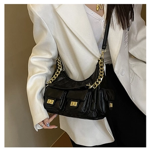 Close-up of quilted black leather shoulder bag featuring gold chain and multi-pockets
