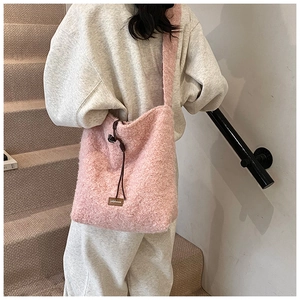 Detalle del bolso tote rosa de felpa con etiqueta de cuero marrón y cordón