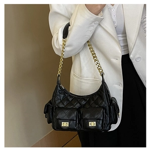 Detail of black quilted chain bag featuring multiple pockets with gold metal clasps