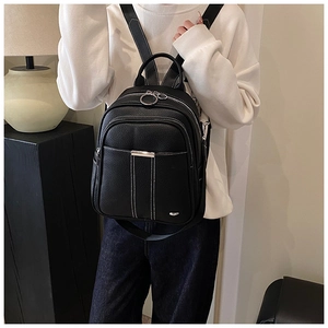 Detail of black lychee grain leather backpack with white stitching and silver hardware