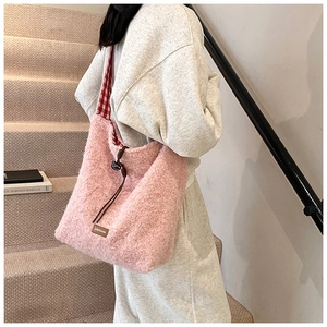 Detalle del bolso tote de felpa rosa con correas de cuadros rojos y cordón ajustable
