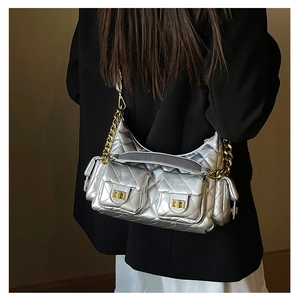 Detail of silver quilted chain bag featuring gold hardware and multiple utility pockets