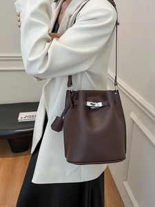 Minimalist dark brown lychee leather bucket bag with silver lock and shoulder strap