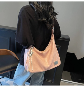 Detail of pink hobo bag showing retro faux leather texture and knot tassel charm