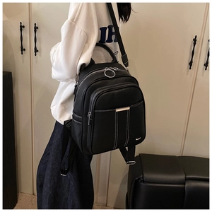 Detailed view of the black lychee pattern leather texture and metal ring on the backpack