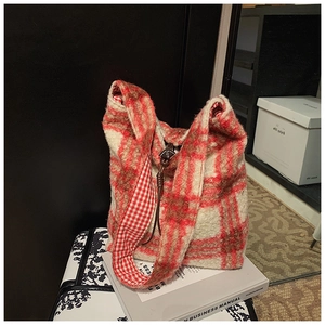 Detalle del bolso de peluche a cuadros rojos y blancos con flecos y correa vichy