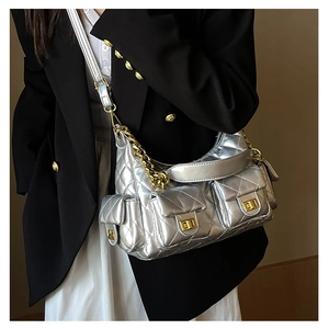 Silver quilted chain bag with multiple pockets worn by model for a luxury fashion look