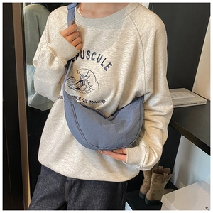 Blue crescent nylon crossbody bag shown on model for a trendy casual daily look
