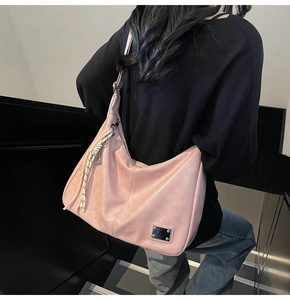 Close-up of dusky rose leather half-moon tote bag with stylish cord pendant detail