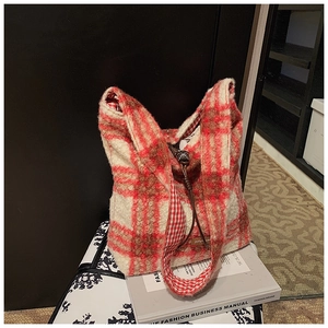 Detalle del bolso tote de peluche a cuadros rojos y blancos con etiqueta de cuero