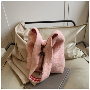 Detalle de bolso tote de felpa rosa con forro de cuadros y cierre de cordón ajustable