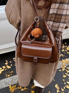 Sac cabas vintage marron foncé avec charm doudou porté sur une tenue d'automne