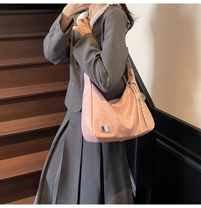 Pink leather hobo bag with vintage texture and woven lanyard detail on model