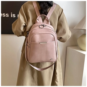 Close-up of pink lychee grain faux leather backpack with silver ring zippers and straps