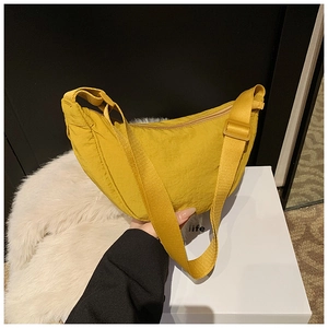 Detail view of bright yellow nylon crescent bag with adjustable wide shoulder strap