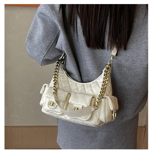 White quilted shoulder bag with multi-pocket design and golden chain strap on a model