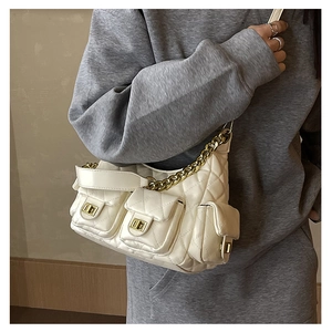 Detailed view of quilted white crossbody bag with gold chain and multi-pocket design