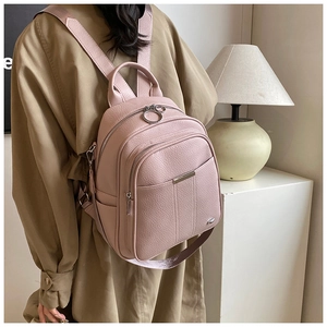 Detail of pink lychee grain PU leather backpack with silver ring zippers and fabric straps