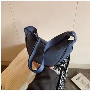 Close-up of a navy nylon crescent bag showing durable texture and adjustable strap