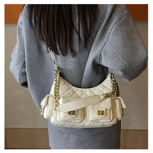 Detailed back view of a white quilted shoulder bag with gold chain straps and side pockets
