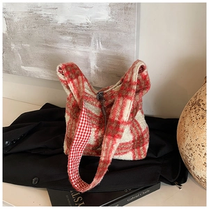Detalle de bolso tote de felpa a cuadros rojos y blancos con textura de lana sobre abrigo