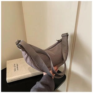 Detail of grey nylon crescent bag with adjustable wide strap and smooth zipper closure