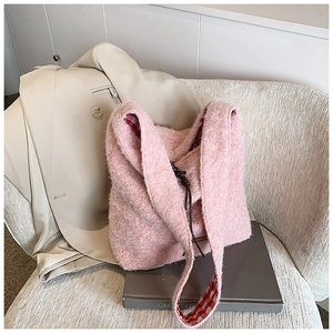 Detalle del bolso tote de felpa rosa con forro de cuadros rojos y blancos en un blazer