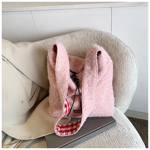 Detalle de bolso tote de felpa rosa con forro a cuadros rojos y textura de piel sintética
