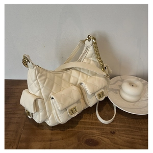 Detail of cream white quilted hobo bag with gold twist locks and chain strap