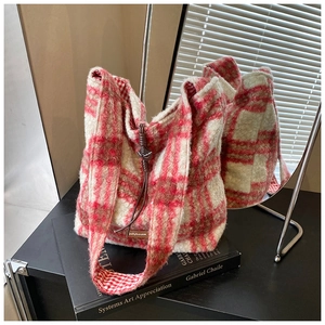 Detalle del bolso tote de lana de cordero a cuadros rojos y blancos con etiqueta de cuero