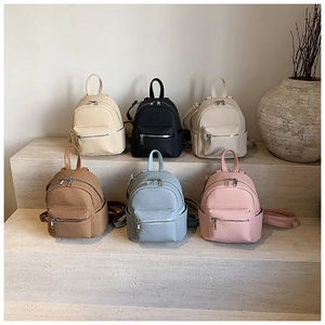 Modern mini backpacks in six colors with woven texture on elegant stone display