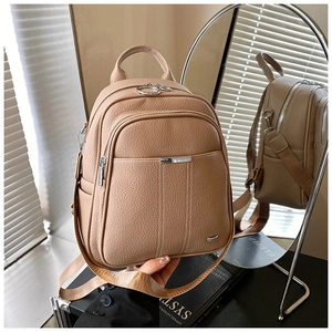 Detail of khaki faux leather backpack with litchi texture and silver hardware accents