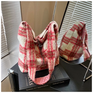 Detalle del bolso tote de tweed a cuadros rojos y blancos con textura y logotipo