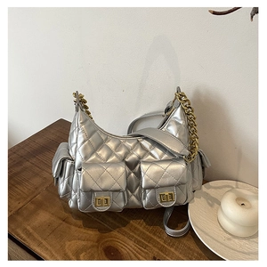 Detail of silver quilted leather handbag with gold twist-locks and metal chain handles
