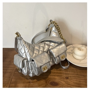 Detailed view of silver quilted shoulder bag featuring three outer pockets with gold twist locks