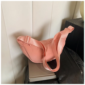 Detail of pink nylon crescent bag with wide adjustable shoulder strap and smooth texture