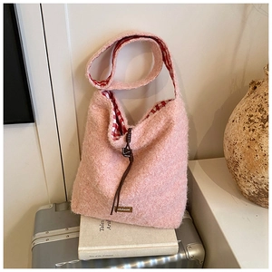 Detalle del bolso tote de felpa rosa con textura suave de sherpa y forro de cuadros