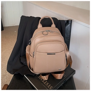 Close-up of beige lychee grain leather backpack with metal ring zipper and top handle