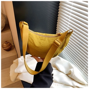 Detail of adjustable strap and mustard yellow nylon crescent bag on a model