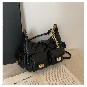 Close-up of black quilted shoulder bag featuring gold twist locks and multi-pocket design