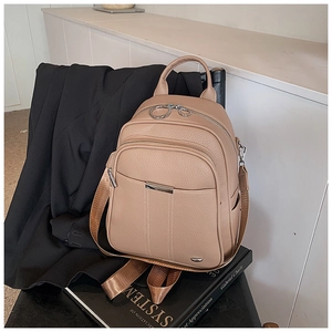 Detail of lychee pattern leather backpack with silver zippers and nylon straps