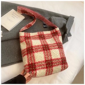 Primer plano del bolso tote a cuadros rojos y beige con suave textura de felpa