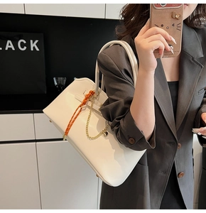 Fashionable ivory tote bag with woven rope detail shown in a modern lifestyle setting