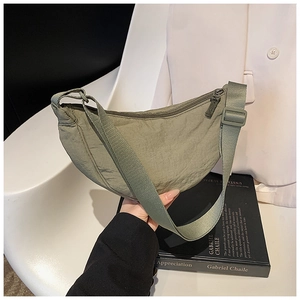 Close-up of sage green nylon crescent bag with adjustable strap and textured fabric