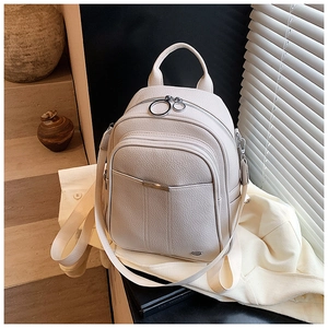 Detail of off-white pebble leather backpack with gold zippers and metal hardware