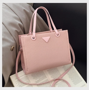 Detail view of pink tote bag with textured finish, sturdy handles and metallic hardware